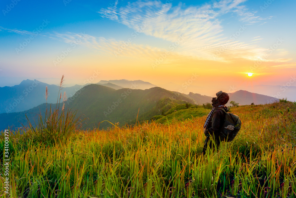 Man's silhouette on sunset mountains backdrop 
