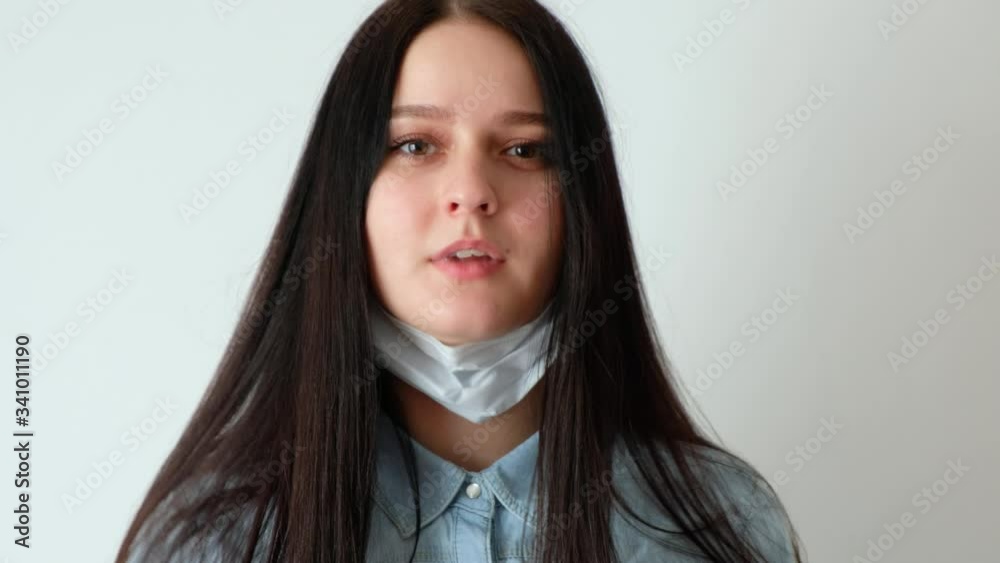 closeup of a young smiling woman, a girl with long brown hair takes off ...