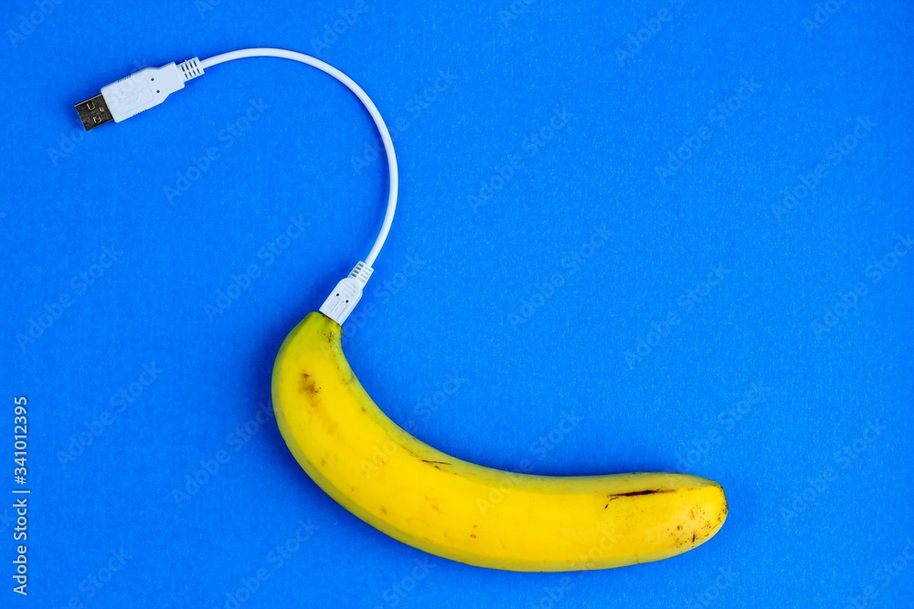 A fresh ripe banana connecting with a white usb charge cable. Creative  concept of alternative electricity source, battery charger indicator,  energy, healthy food. Stock Photo | Adobe Stock