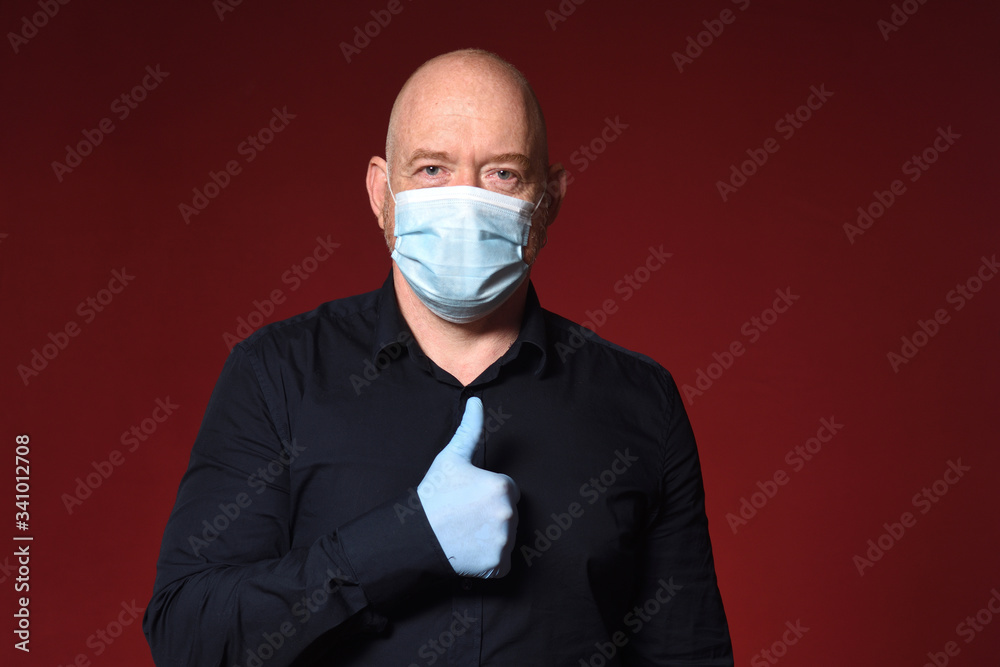 portrait of a man with gloves and mask thumbs up on a red background portrait of a man with gloves and mask thumbs up on a red background