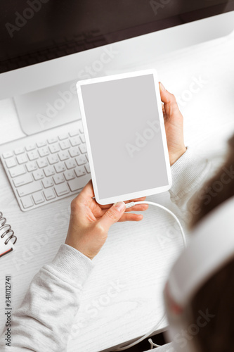 Digital tablet with a blank screen in the hands of a girl. Place for text. © Oleksandr