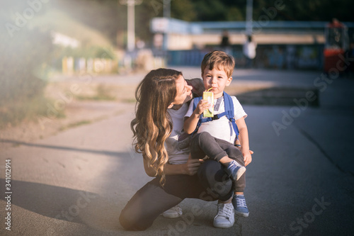 Young mom hugging her son while he is holidn a teddy bear. photo