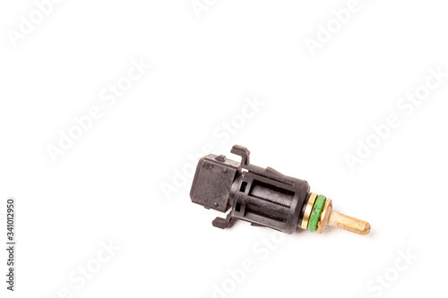 Black coolant temperature sensor on a white background with yellow metal elements. The engine control unit corrective composition of the air-fuel mixture, the engine idle speed, the ignition timing.