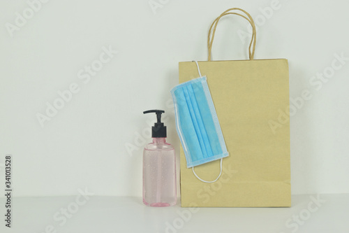 Shopping bag with hygienic face mask, Alcohol gel Sanitizer hand gel cleaner on the side. Concept for shopping during the Coronavirus (COVID-19) pandemic.