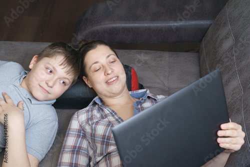 Mother and her children are talking online by notebook with relatives or friends. Online call friends, grandparents. Family in quarantine stay at home in self isolation.