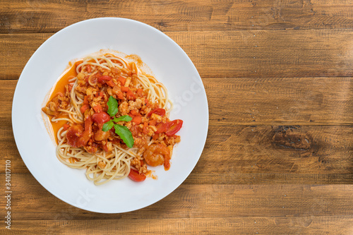 spaghetti with tomato sauce on wood table with copy space 