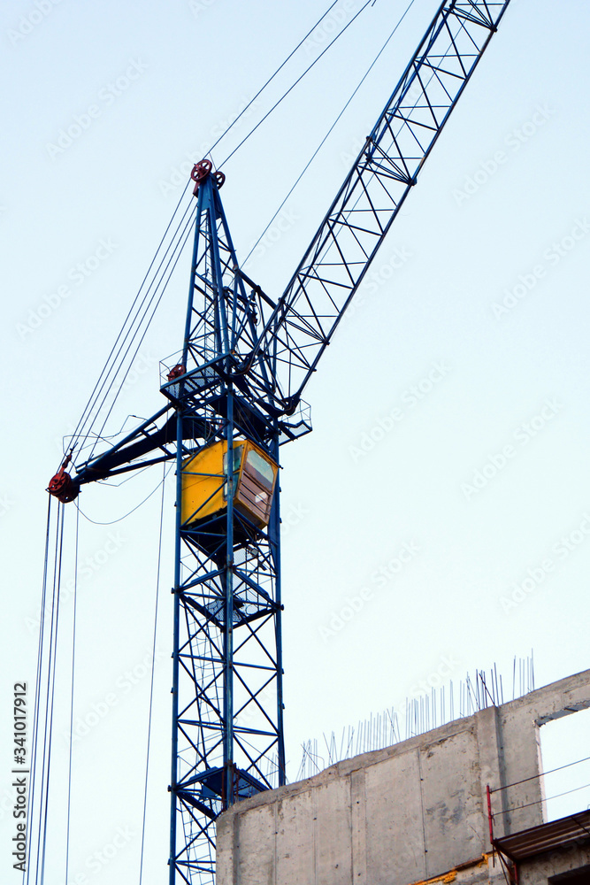 Crane. Self-erection crane near concrete building. Construction site.