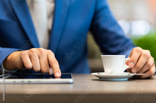 Man having coffee and using tablet