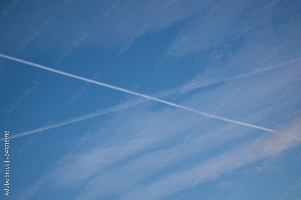 Two traces from planes crossing in the sky blue sky with some thin clouds Two traces from planes crossing in the sky blue sky with some thin clouds