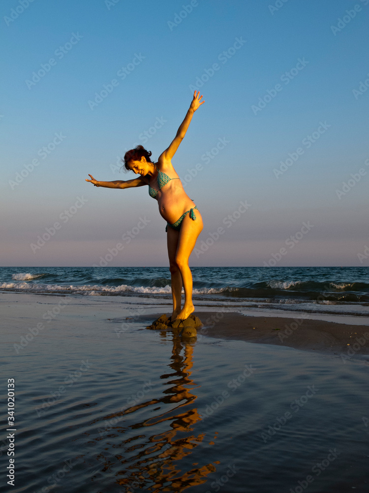 Pregnant woman plays in the water Pregnant woman plays in the water