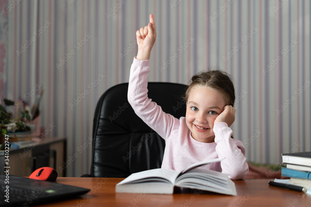 little girl sitting at home doing homework. I came up with a solution to the problem. . The concept of studying at home alone during quarantine. little girl sitting at home doing homework. I came up with a solution to the problem. . The concept of studying at home alone during quarantine.