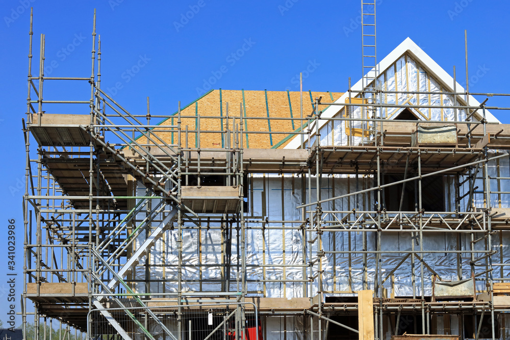 Scaffolding surrounding a timber frame structure.