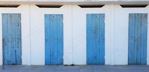 Blue wooden doors arranged in a row.