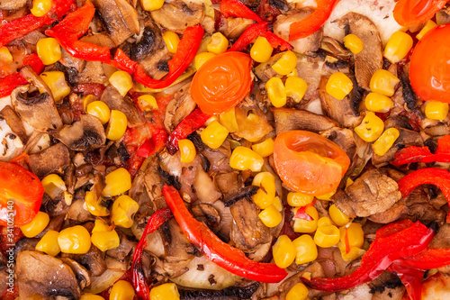 Macro photography of pizza with mushrooms, corn, cherry tomatos, courgettes and bell peppers or Veggie Vegetarian pizza, close up view © Kindarts
