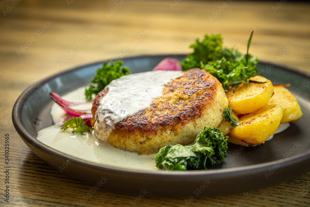 Cooked cod fish cutlet with potatoes, lettuce