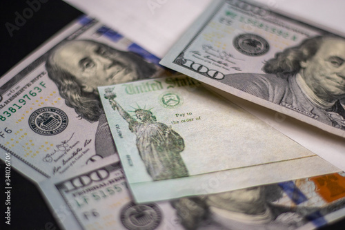 United States Treasury check issued for Economic Impact Payment or IRS Tax Refund with US Currency Illustrative editorial COVID-19 Pandemic stimulus check Coronavirus.