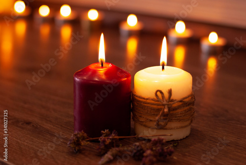 Aromatherapy flame closeup picture. Beautyful burning light yellow creme vanilla and red candles with wooden background