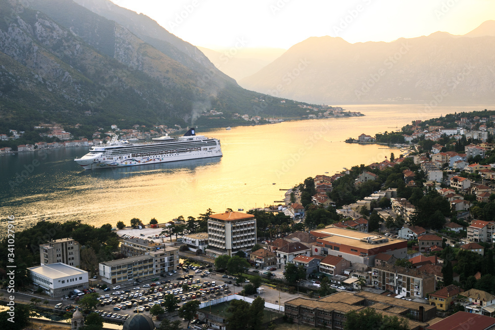A large liner stands in the Bay of Kotor in Montenegro. The liner is anchored in a picturesque place.