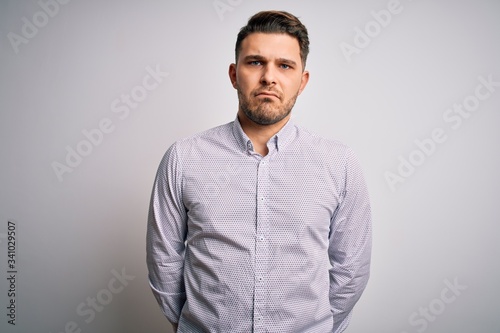 Young business man with blue eyes standing over isolated background depressed and worry for distress, crying angry and afraid. Sad expression.
