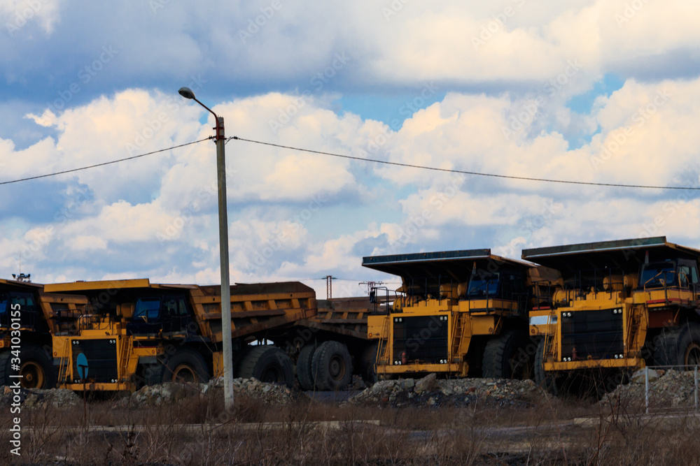 Huge yellow dump trucks on a parking near quarry