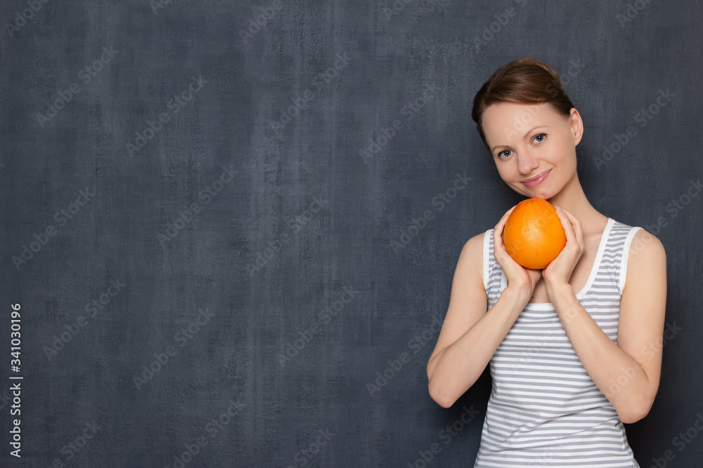 Portrait of happy woman holding fresh grapefruit in hands and smiling Portrait of happy woman holding fresh grapefruit in hands and smiling