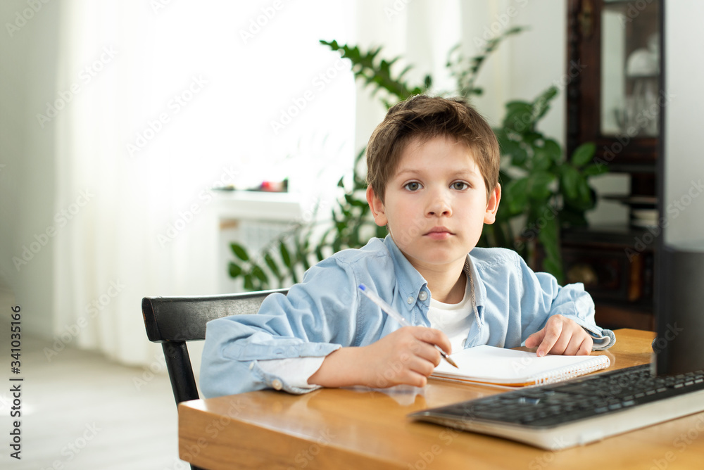 Distance learning during isolation during quarantine in coronavirus. Boy and laptop at home. Lifestyle Distance learning during isolation during quarantine in coronavirus. Boy and laptop at home. Lifestyle