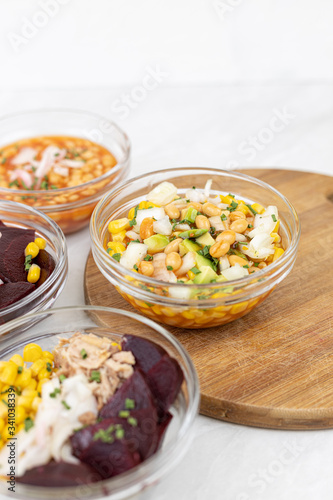 Mixed salads with avocado corn beans beet and onions in bowls