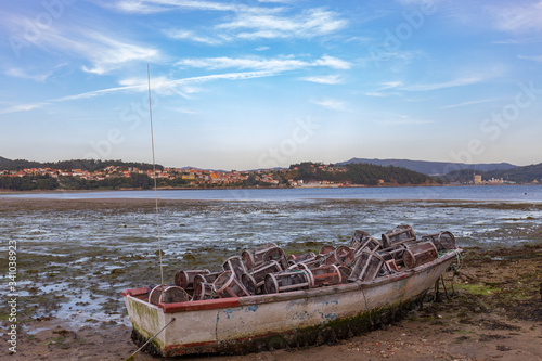 Small abandoned boat full of fishing tools on a Combarro beach in Galicia  Spain.