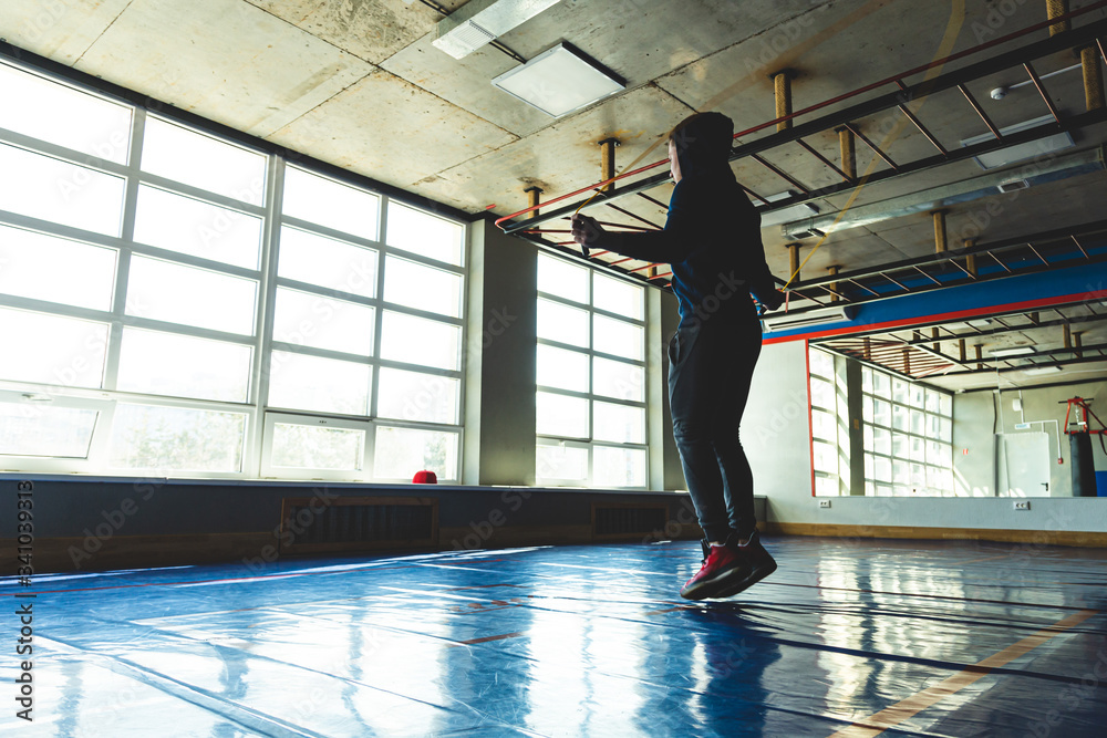 Attractive sporty man is exercising in gym. Jumping rope. Attractive sporty man is exercising in gym. Jumping rope.