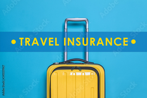 Yellow suitcase and phrase TRAVEL INSURANCE on blue background