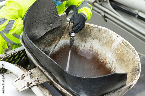 constuction site with worker at equipment cleaning with hose and water pressure photo