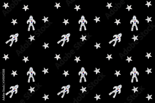 Seamless pattern made of silver astronauts and stars on black