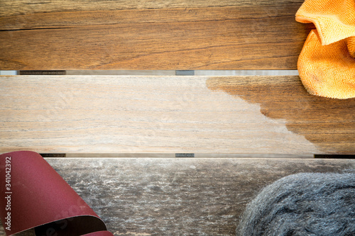 Sandpaper and oil cloth lying on wooden garden table after sanding and oiling