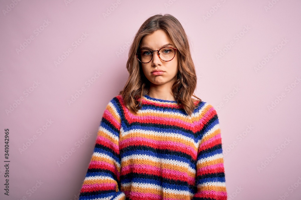 Young beautiful blonde girl wearing glasses and casual sweater over pink isolated background skeptic and nervous, frowning upset because of problem. Negative person. Young beautiful blonde girl wearing glasses and casual sweater over pink isolated background skeptic and nervous, frowning upset because of problem. Negative person.
