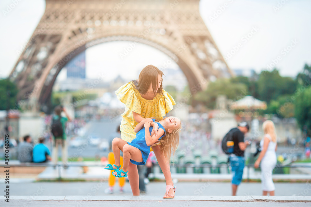 Obraz premium Little adorable girl and her young mom in Paris near Eiffel Tower during summer vacation
