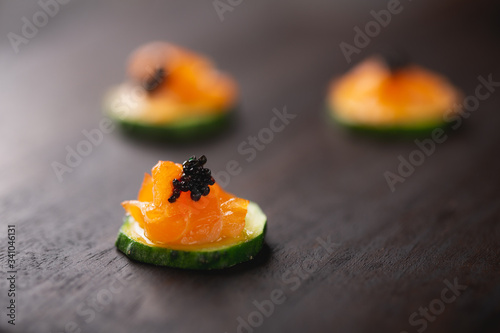 small catering snacks, cucumber with smoked salmon and black caviar