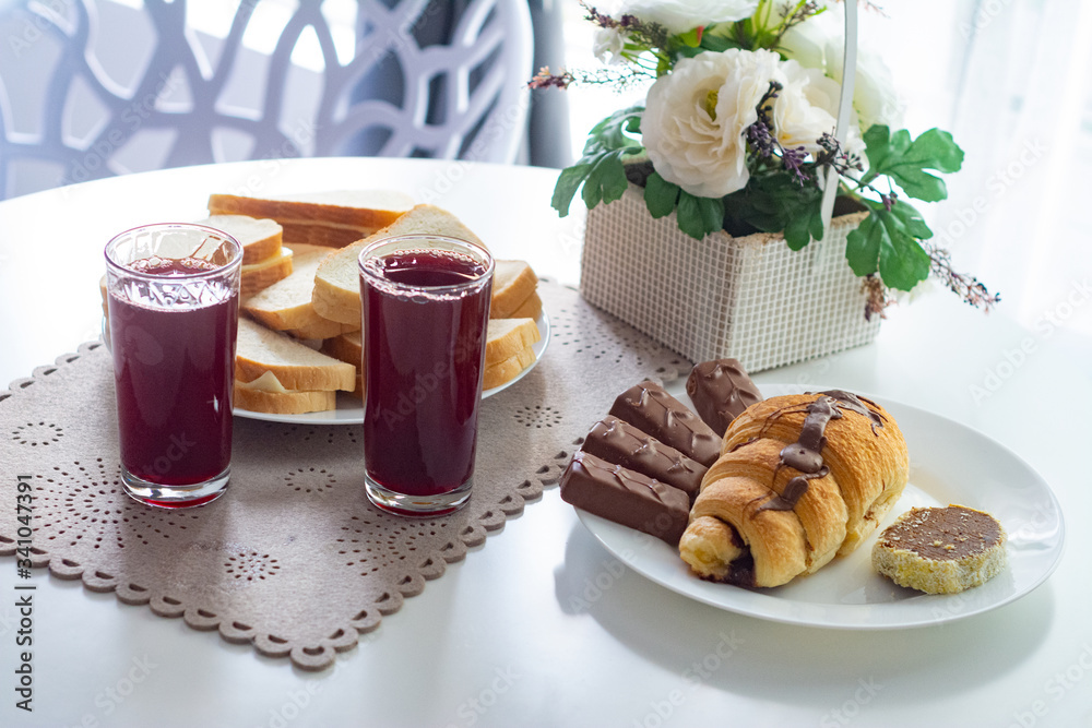 Berry juice, croissants and sweets on the table.