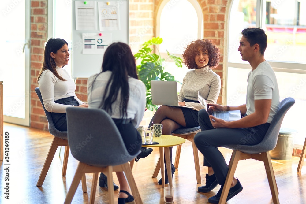 Group of business workers smiling happy and confident. Sitting on chairs relaxed with smile on face. Speaking taking rest at the office Group of business workers smiling happy and confident. Sitting on chairs relaxed with smile on face. Speaking taking rest at the office