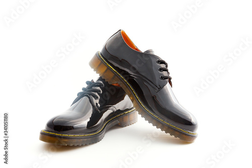 Black shiny leather shoes for woman. Female fashion footwear on white background. Formal trendy oxford boots.