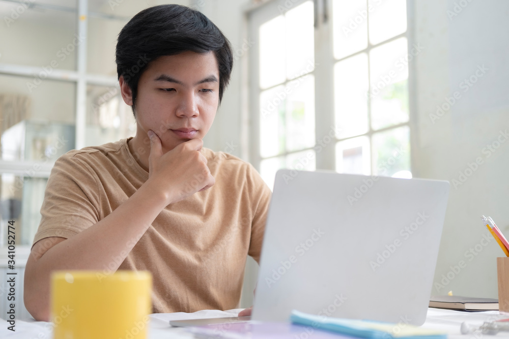 Young man using laptop for working from home office Young man using laptop for working from home office