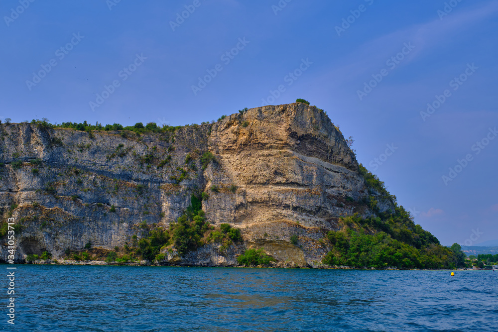 Rocks on lake Garda overhanging the water summer season