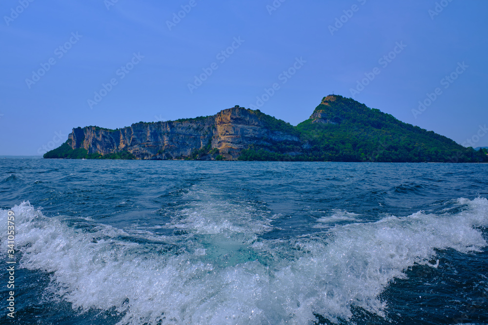A trace on the water from a boat against the background of a rock blue sky A trace on the water from a boat against the background of a rock blue sky