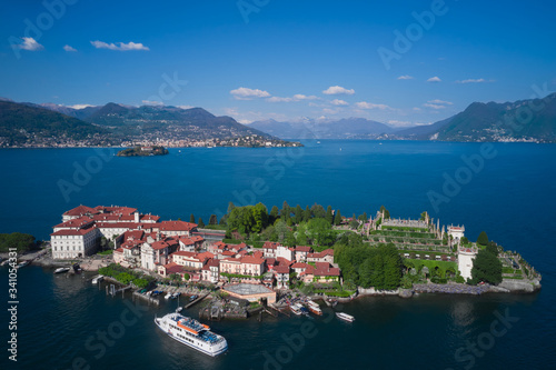 Isola Bella is located on Lake Maggiore in Italy. Magnificent garden Borromee in the background the alps in the snow, clouds in the blue sky. The ship is sailing to the island