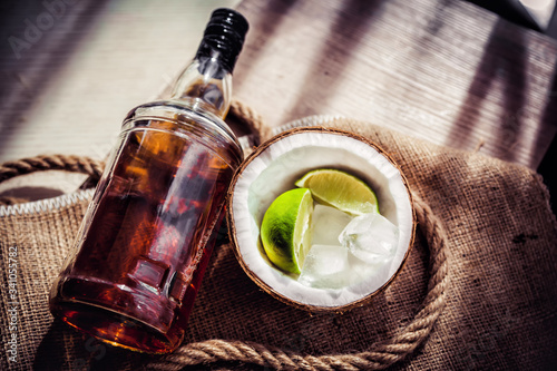 Bottle of rum with lime ice and coconut, coconut glasses and rum
