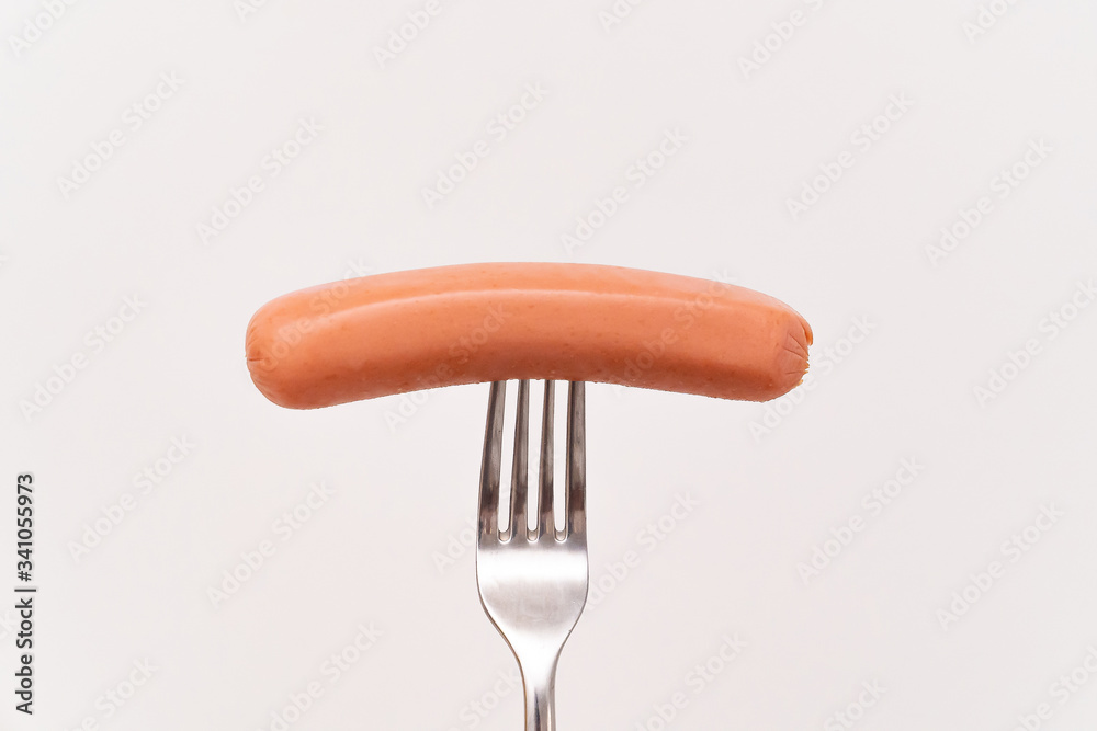 Raw frankfurter sausage on a fork isolated Raw frankfurter sausage on a fork isolated