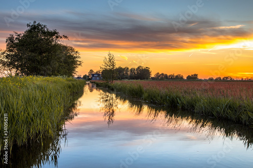 Sunset over canal in Historic dutch landscape