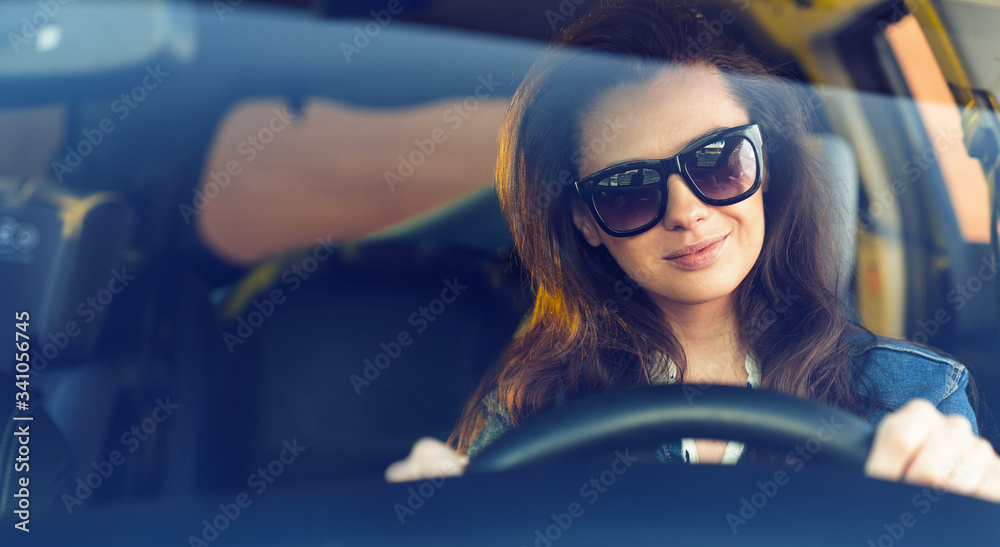 Cheerful woman riding a car in a sunny day