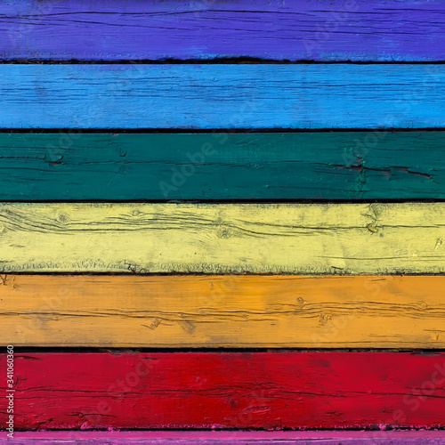 square bright textured background from old wooden planks painted in different colors of the rainbow