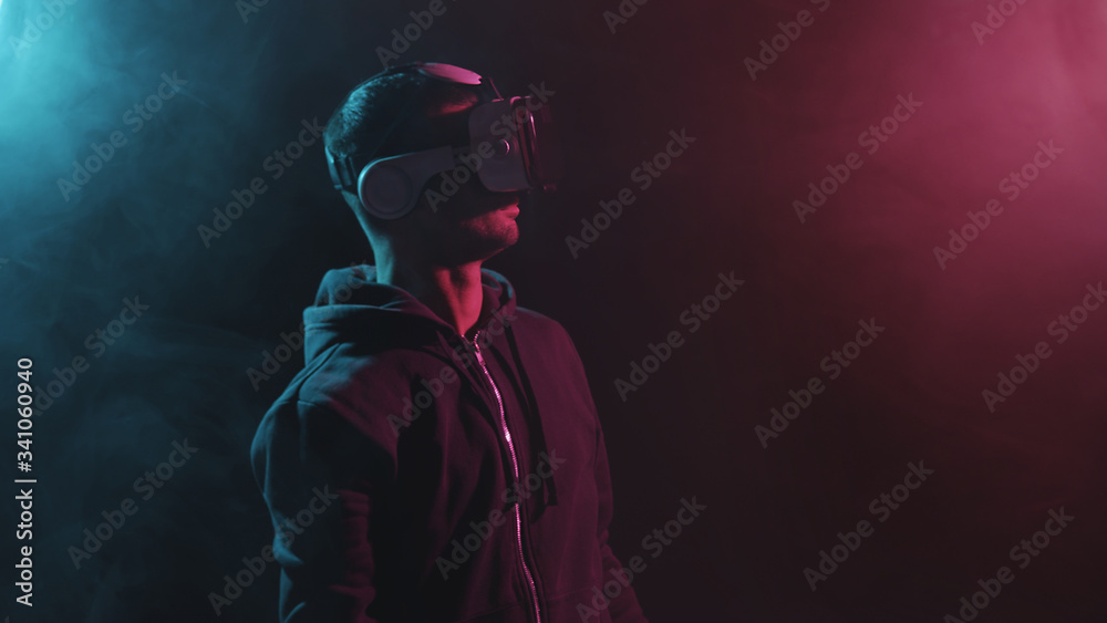 Portrait of a man in virtual reality helmet. Obscured dark face in VR goggles. Internet, darknet, gaming and cyber simulation. Portrait of a man in virtual reality helmet. Obscured dark face in VR goggles. Internet, darknet, gaming and cyber simulation.