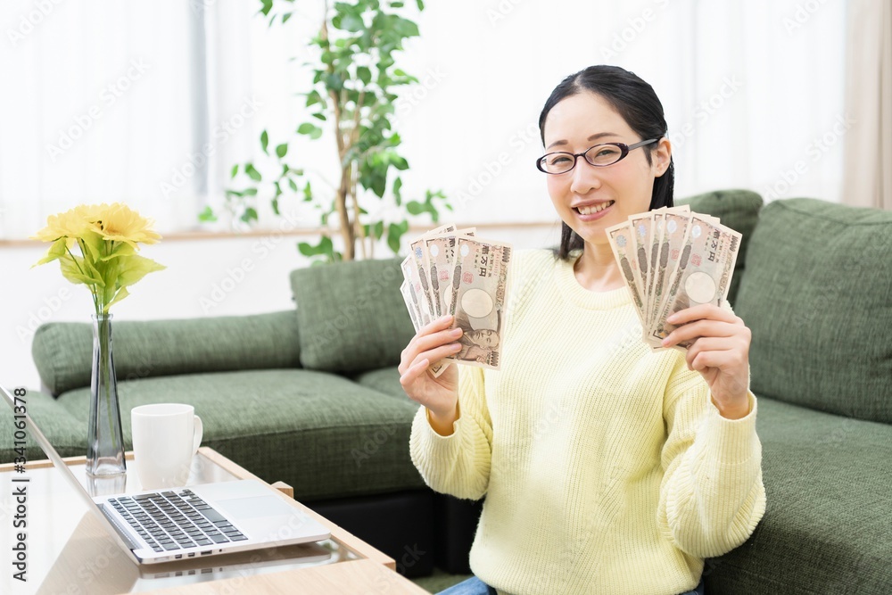 お金を手に持つ女性